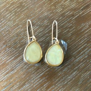 Cream colored earring with gold trim